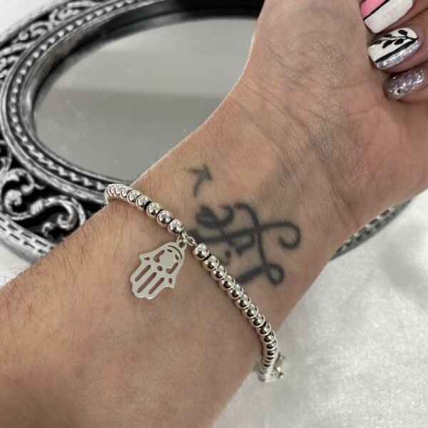 a pulsera bolitas con dije mano fatima